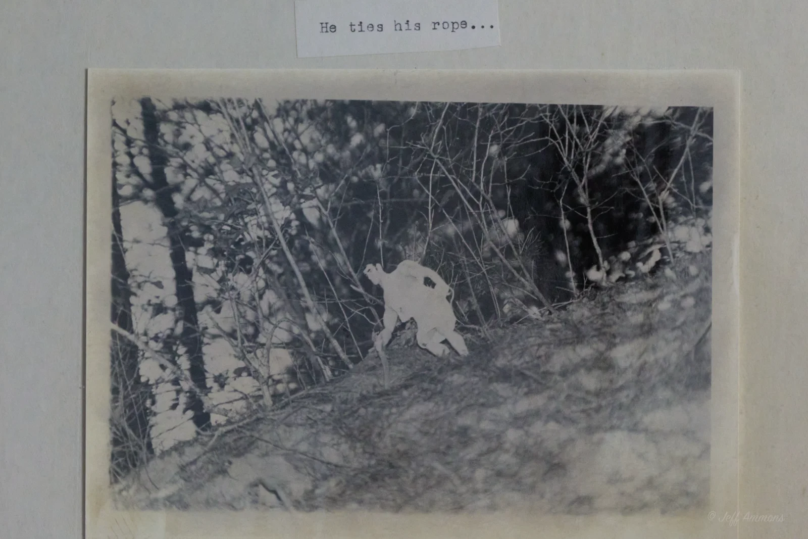 Heracles ties a rope on a wooded hillside in preparation to enter the lion's lair.